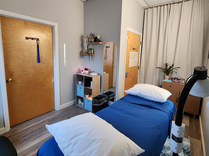 Serene treatment room with calming warm lighting and clean white linens